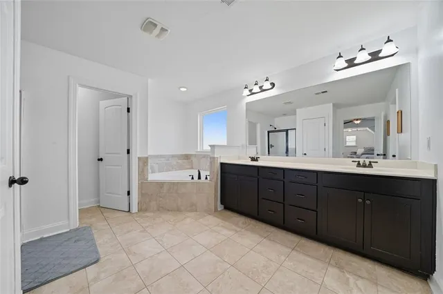 a spacious bathroom with a granite countertop sink a toilet a mirror and shower