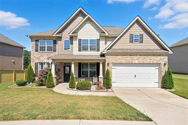 a front view of a house with a yard and garage