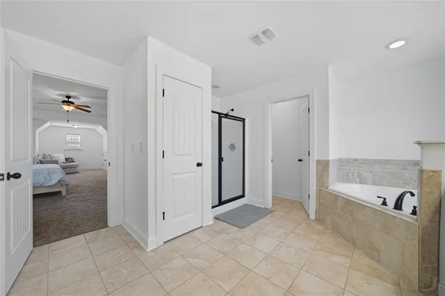 a view of a bathroom with tub mirror and window