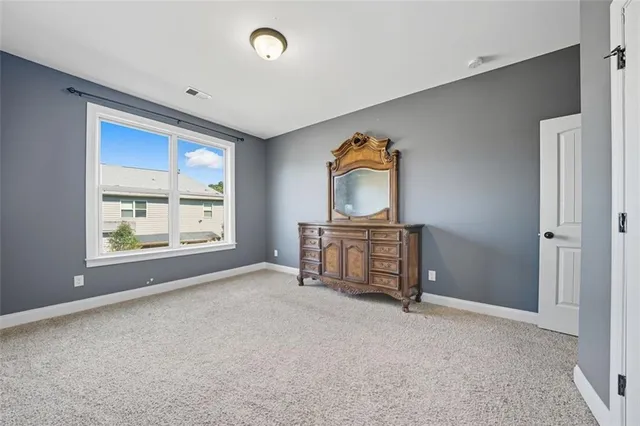 an empty room with windows and cabinet