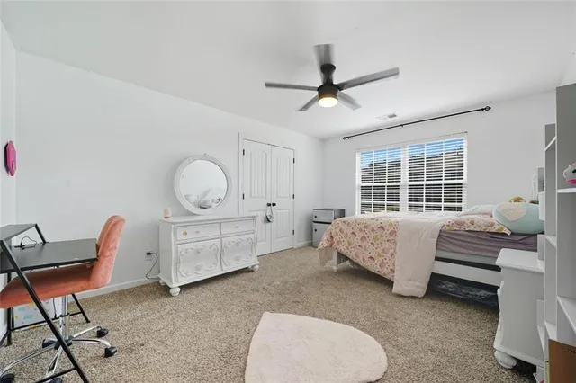 a bedroom with a bed a chair and dresser