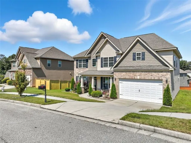 a front view of a house with a yard and garage
