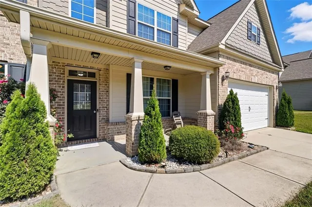 front view of a brick house with potted plants