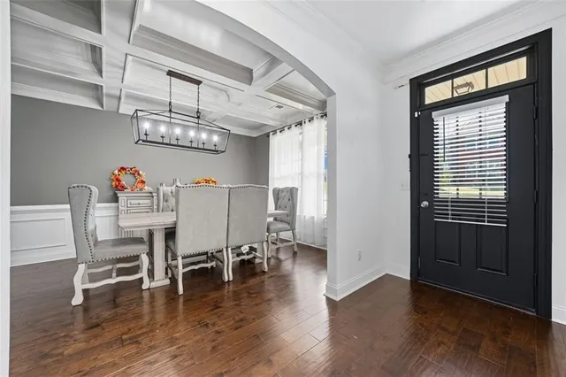 a view of a dining room with furniture a chandelier and wooden floor