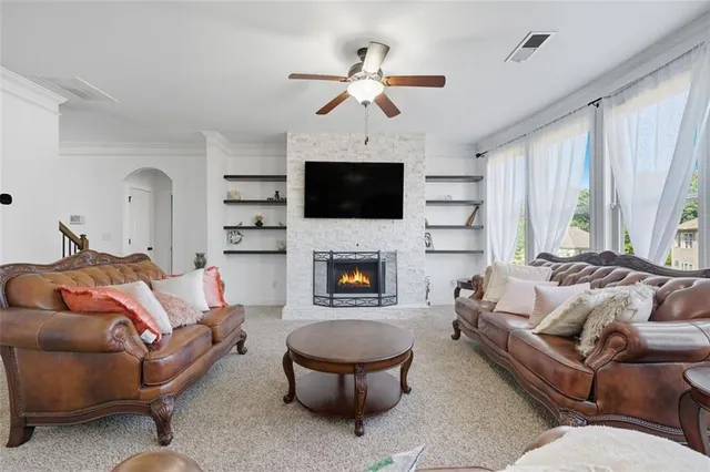 a living room with furniture a flat screen tv and a fireplace