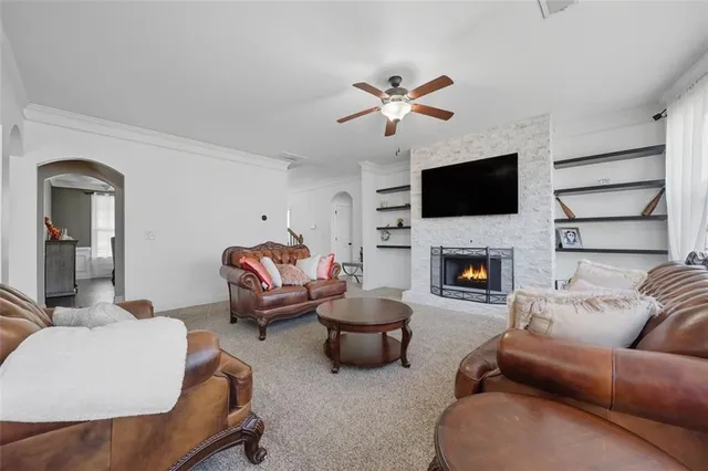 a living room with furniture a flat screen tv and a fireplace