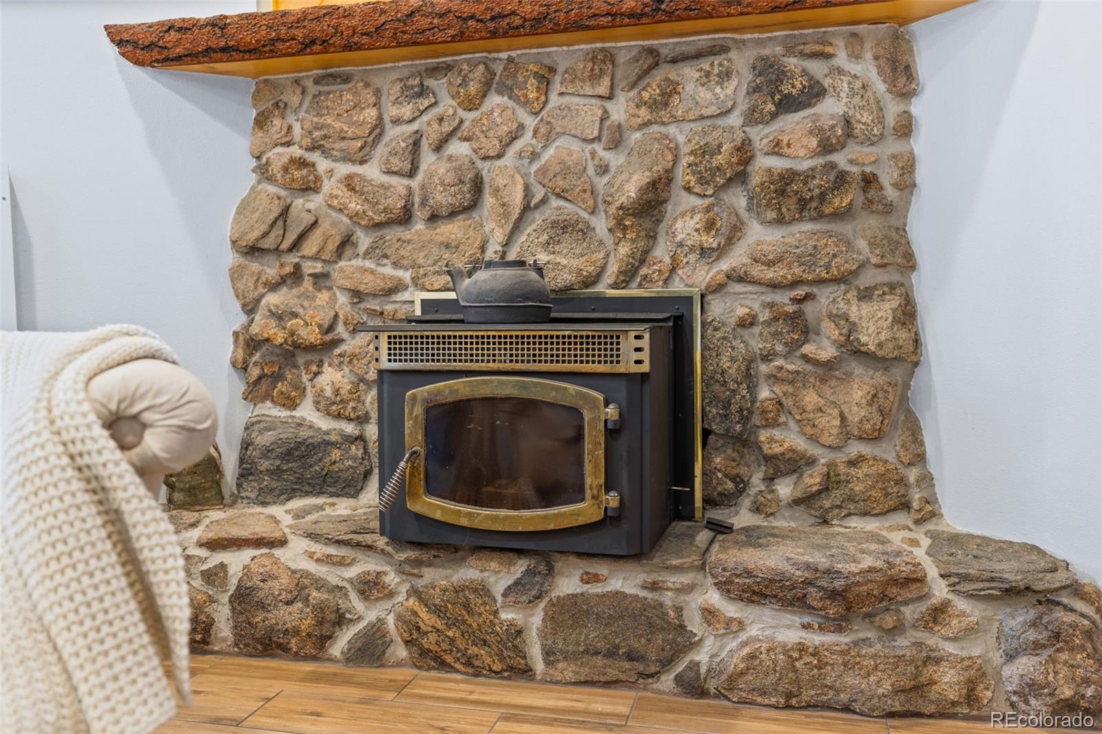 987 Wisp Creek Drive Bailey, CO 80421 - Photo 13 of 22 a living room with a fireplace and a rug