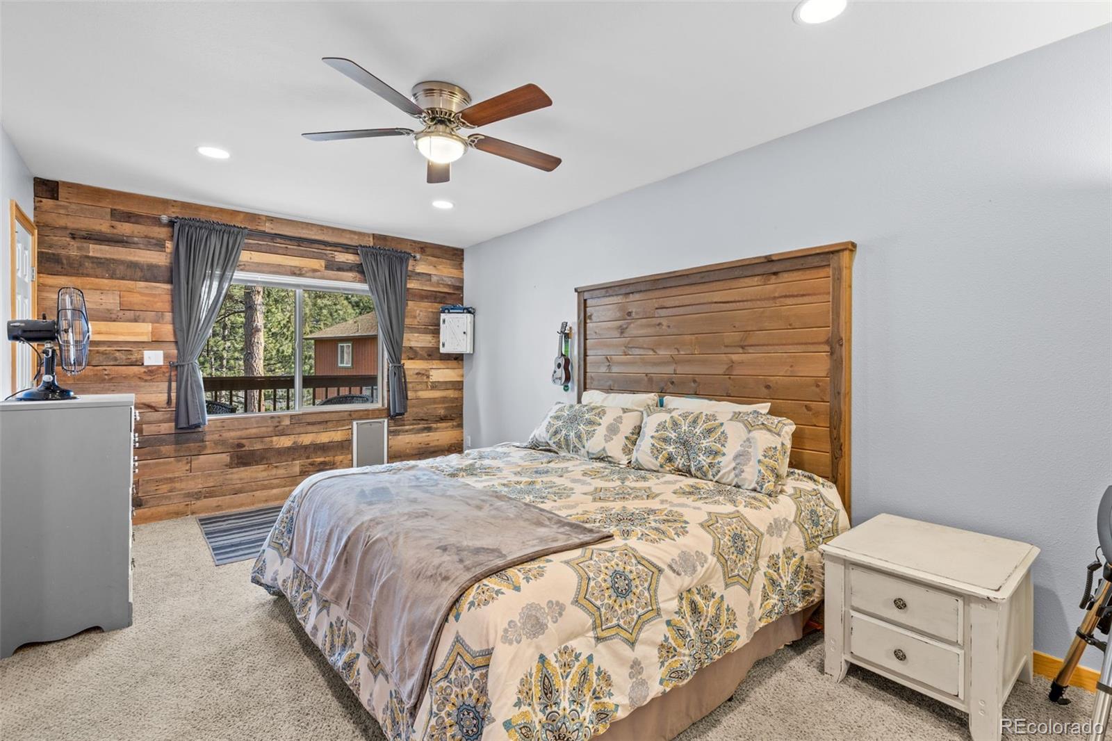 987 Wisp Creek Drive Bailey, CO 80421 - Photo 14 of 22 a bedroom with a large bed and a large window