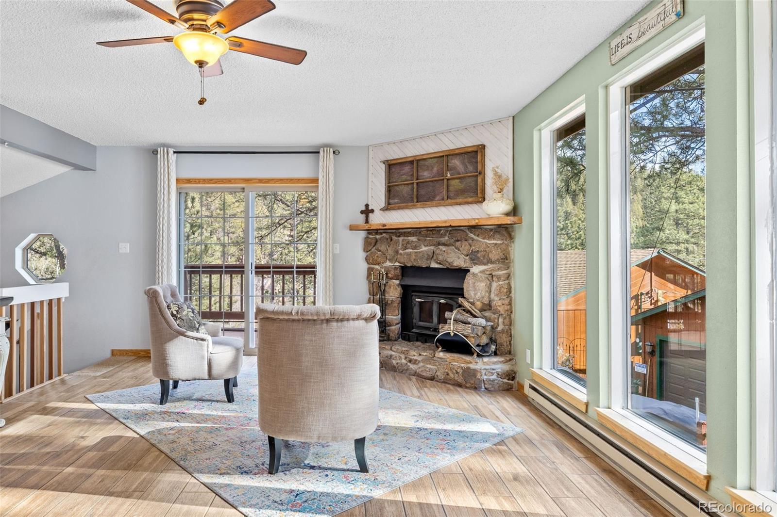 987 Wisp Creek Drive Bailey, CO 80421 - Photo 3 of 22 a living room with furniture and a fireplace