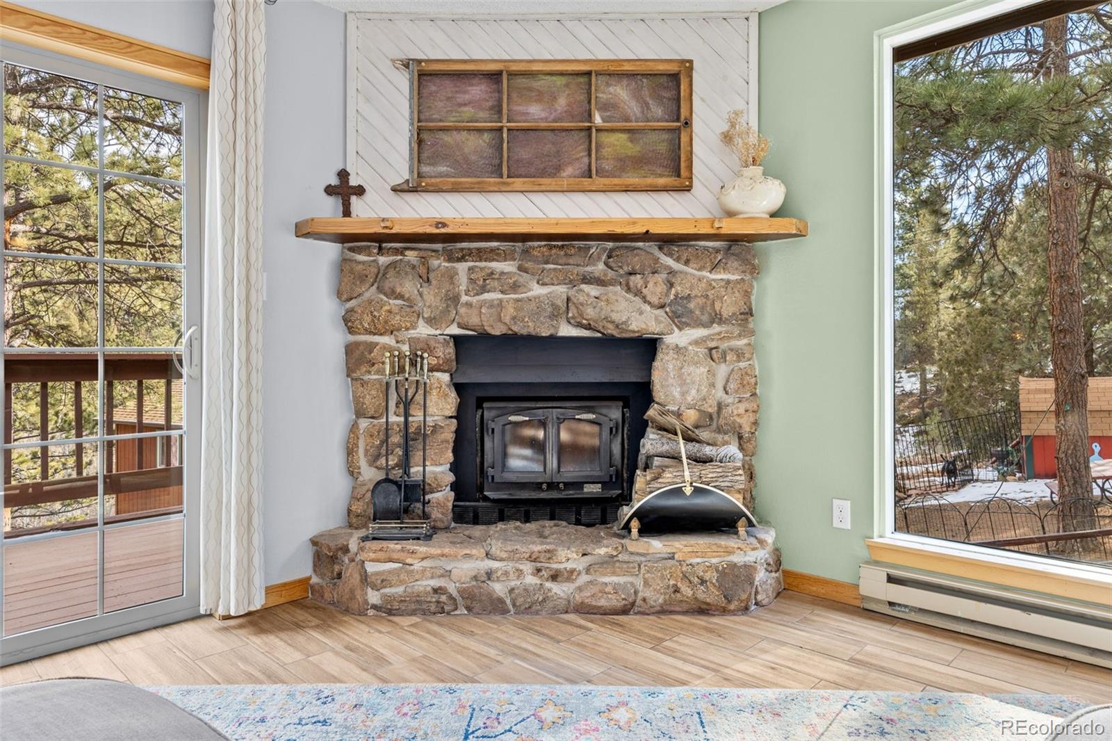 987 Wisp Creek Drive Bailey, CO 80421 - Photo 6 of 22 a living room with a fireplace and a large window