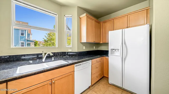 a kitchen with stainless steel appliances granite countertop a refrigerator and a sink
