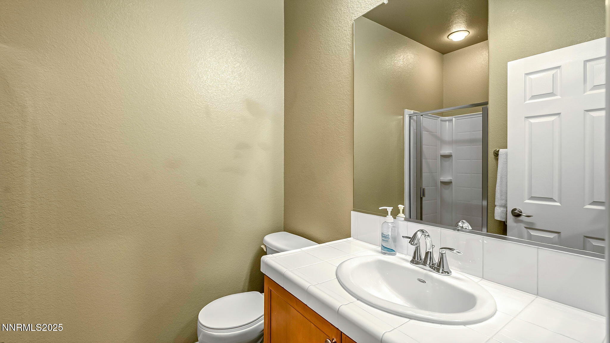225 Gramercy Lane Reno, NV 89509 - Photo 25 of 40 a bathroom with a sink a toilet and mirror