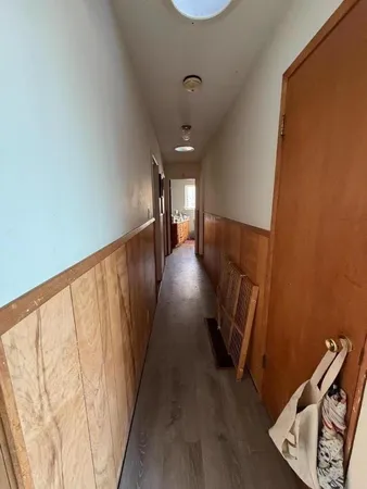 a view of a hallway with wooden floor and stairs