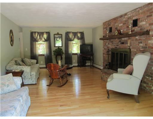 43 Balcom Road Foster, RI 02825 - Photo 4 of 13 Living Room. Oversized Living Room with beautiful brick fireplace and hardwood floors. Sliding glass doors lead out to the wrap-around deck by the pool.