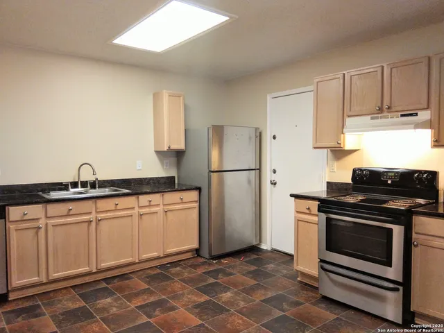 a kitchen with stainless steel appliances a stove a sink and a refrigerator