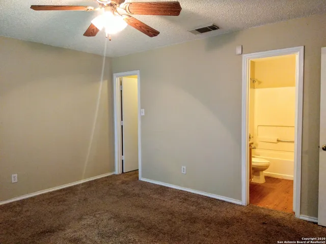 an empty room with chandelier fan