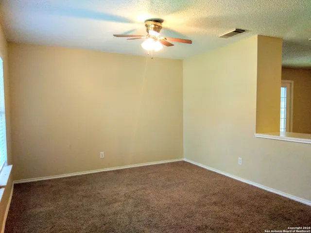 an empty room with a window and a fan
