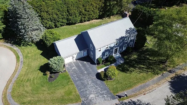 an aerial view of a house with a yard and greenery