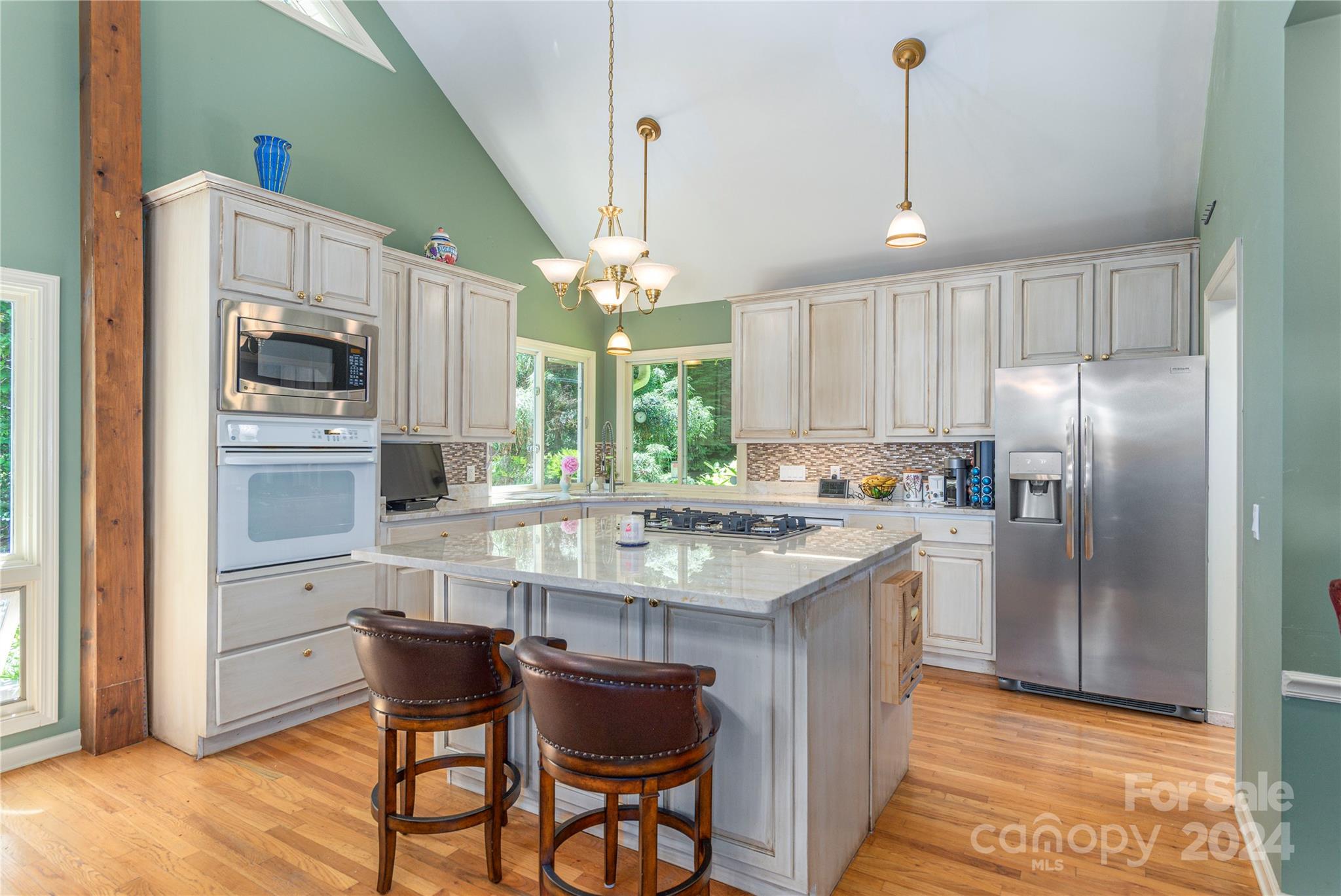 3191 Pigeon Road Waynesville, NC 28786 - Photo 11 of 33 a kitchen with kitchen island white cabinets and stainless steel appliances