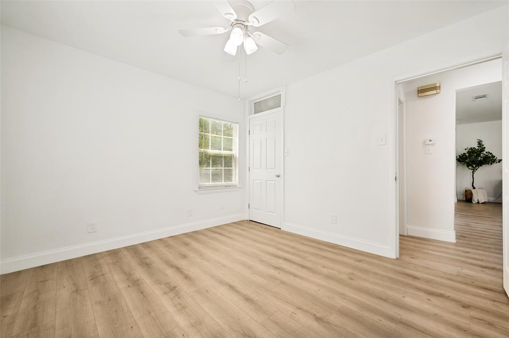2316 Cunningham Street Irving, TX 75062 - Photo 18 of 22 Room featuring wood-finish flooring, white walls, and a multi-pane window