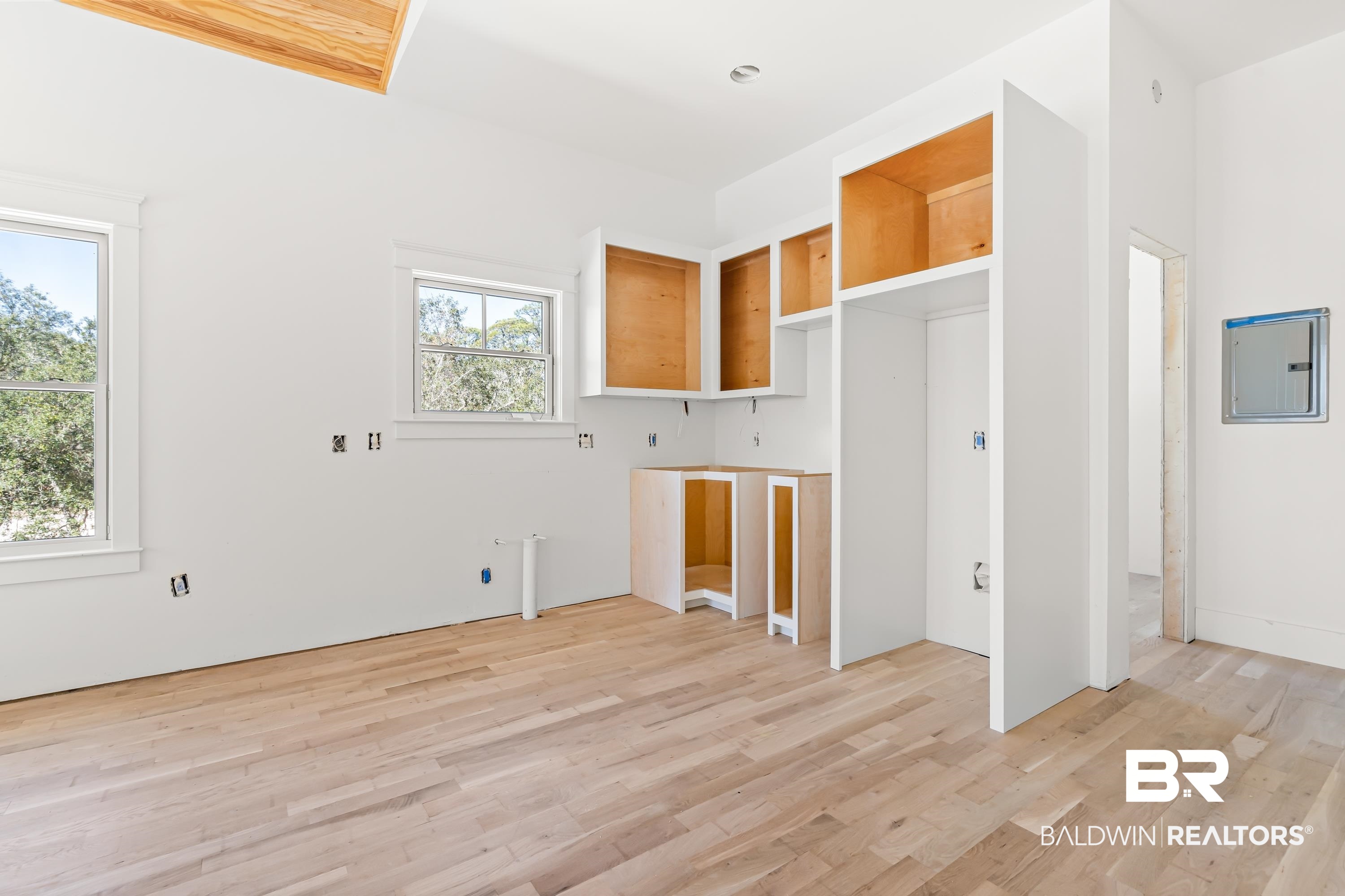 14686 State Highway Gulf Shores, AL 36542 - Photo 6 of 44 Interior space featuring electric panel, light wood-type flooring, and brown cabinetry