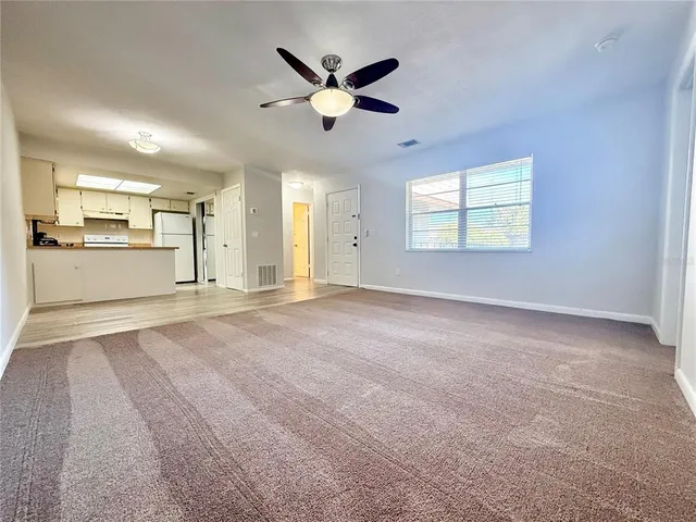a view of an empty room with window and cabinet