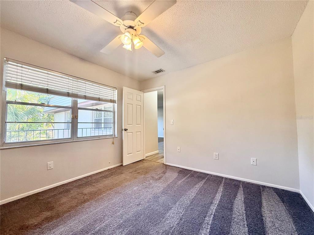 150 Windtree Lane, Unit 150 Winter Garden, FL 34787 - Photo 15 of 31 an empty room with a chandelier fan and windows