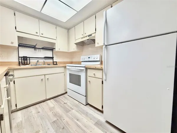 a kitchen with cabinets appliances a sink and a counter space