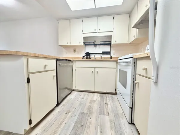 a kitchen with white cabinets and white appliances