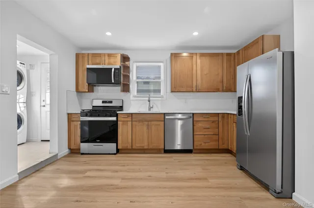 a kitchen with stainless steel appliances granite countertop a refrigerator microwave and sink