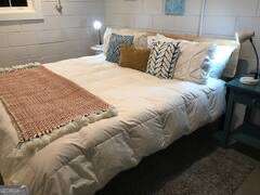 a large bed sitting in a bedroom next to a window