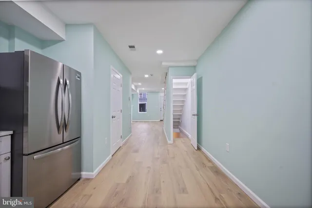 a view of a refrigerator in kitchen and wooden floor