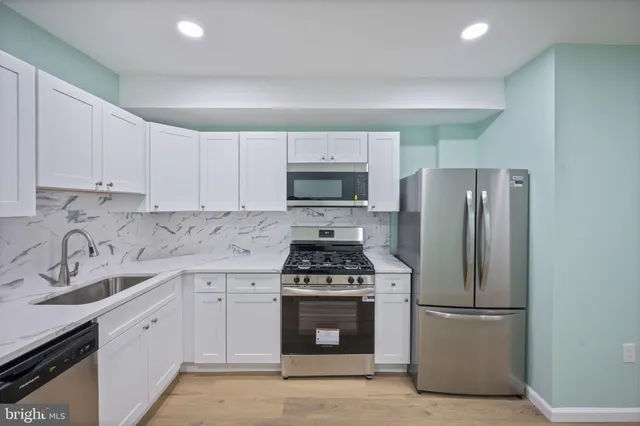 a kitchen with a stove a refrigerator and a sink