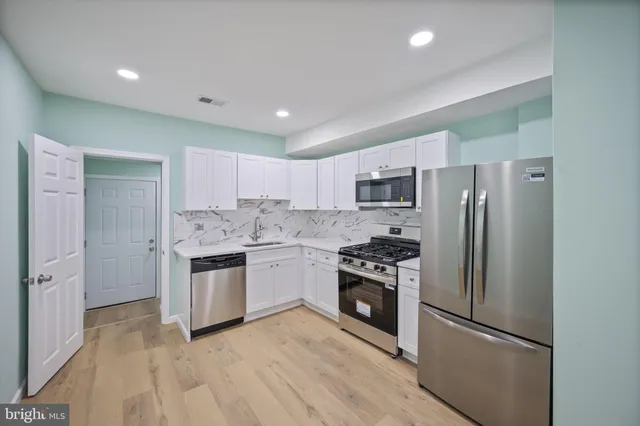 a kitchen with a refrigerator stove and sink