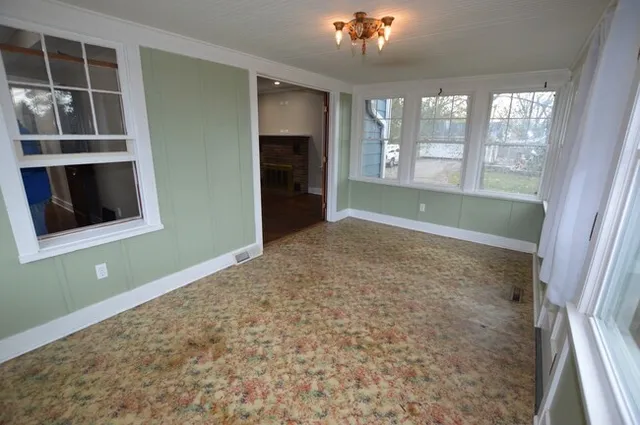 an empty room with windows and cabinet