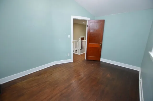 an empty room with wooden floor and closet