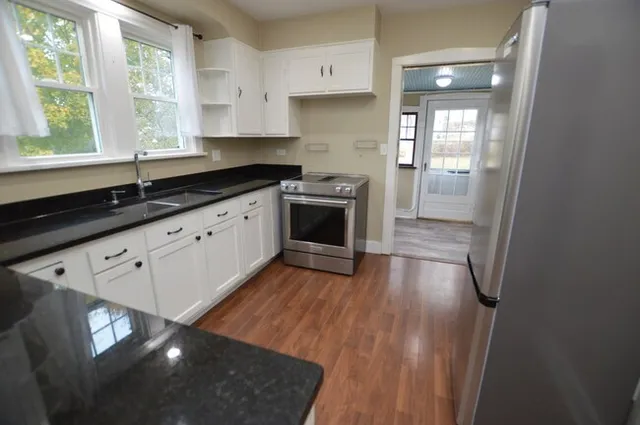 a kitchen with stainless steel appliances granite countertop a stove a sink and a microwave