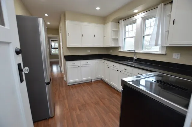a kitchen with granite countertop a sink and a stove top oven