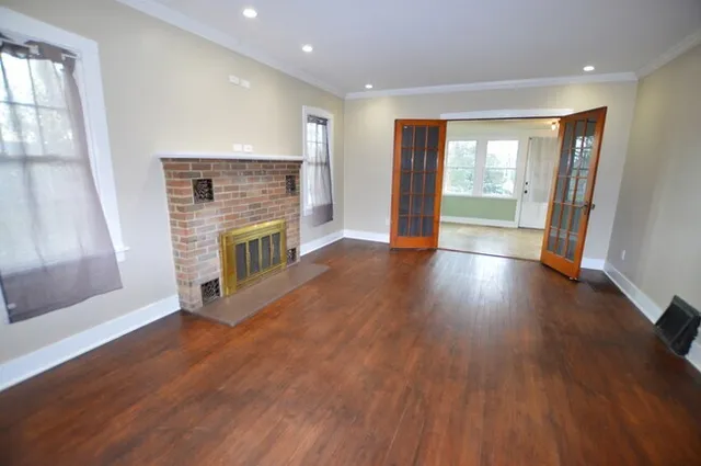 an empty room with wooden floor and fireplace