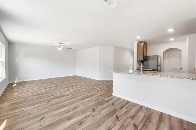 a view of a kitchen with kitchen island a sink stainless steel appliances and cabinets