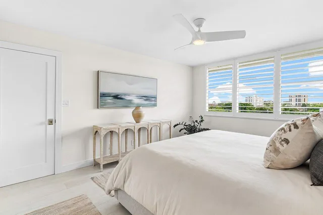 a bedroom with a bed and a large window