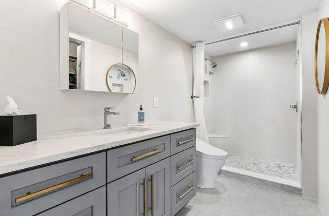 a bathroom with a toilet sink and double vanity