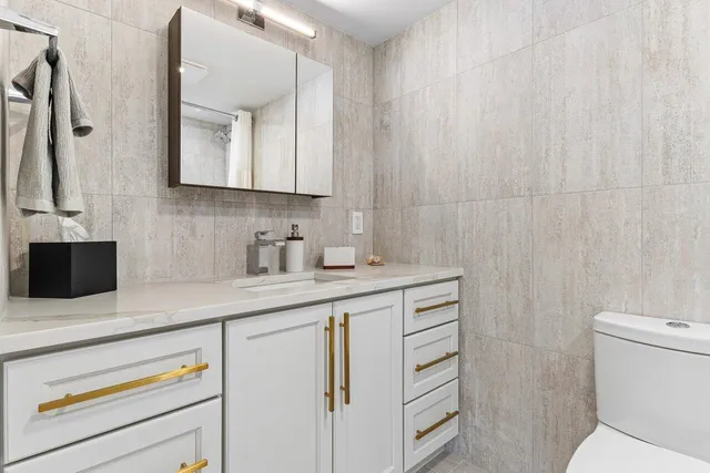 a bathroom with a sink a toilet and a mirror