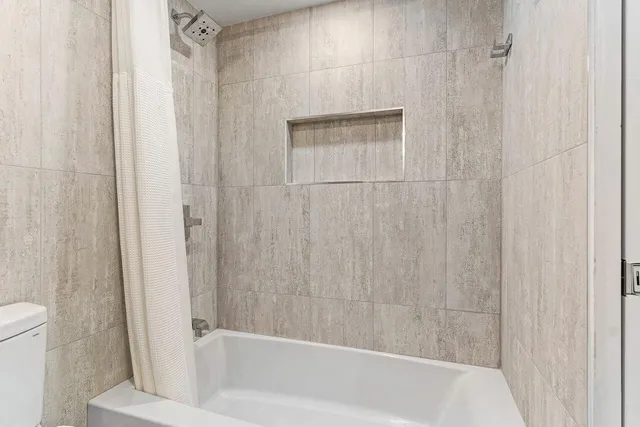 a bath tub sitting next to a white toilet