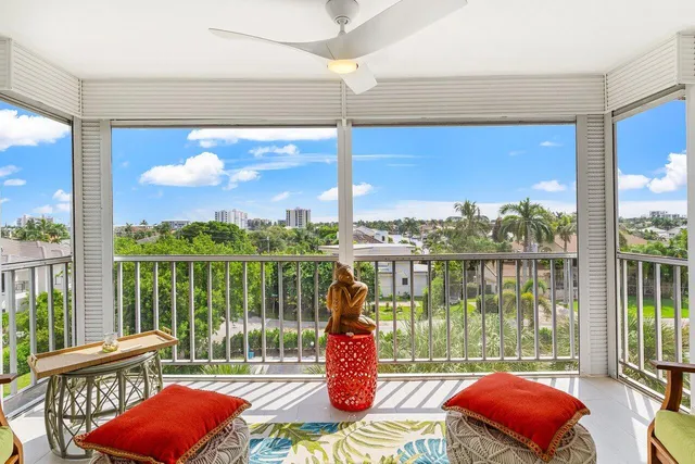 a living room filled with furniture and floor to ceiling windows