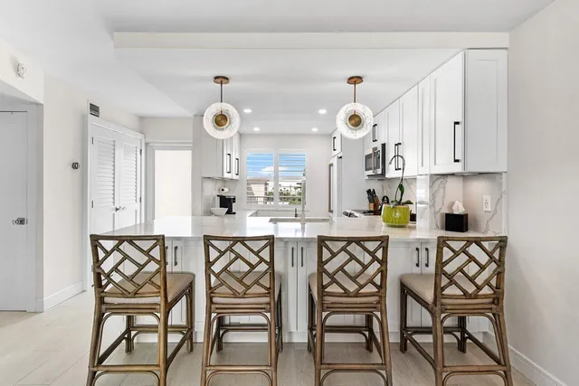 a kitchen with stainless steel appliances a dining table chairs and chandelier