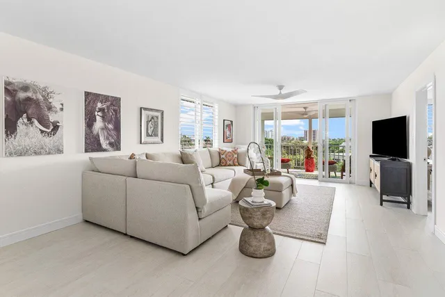 a living room with furniture a flat screen tv and a large window