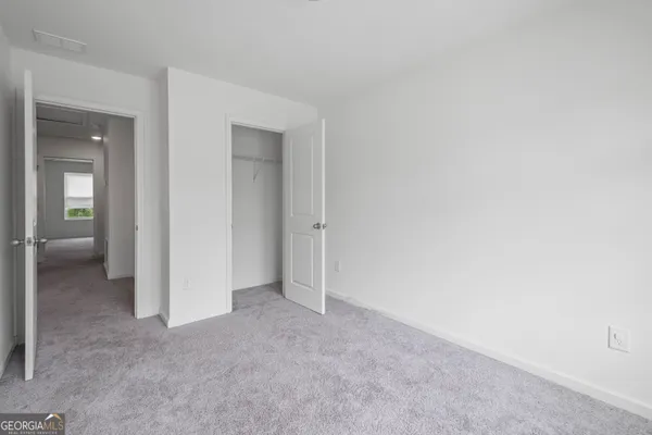 an empty room with closet and a bathroom