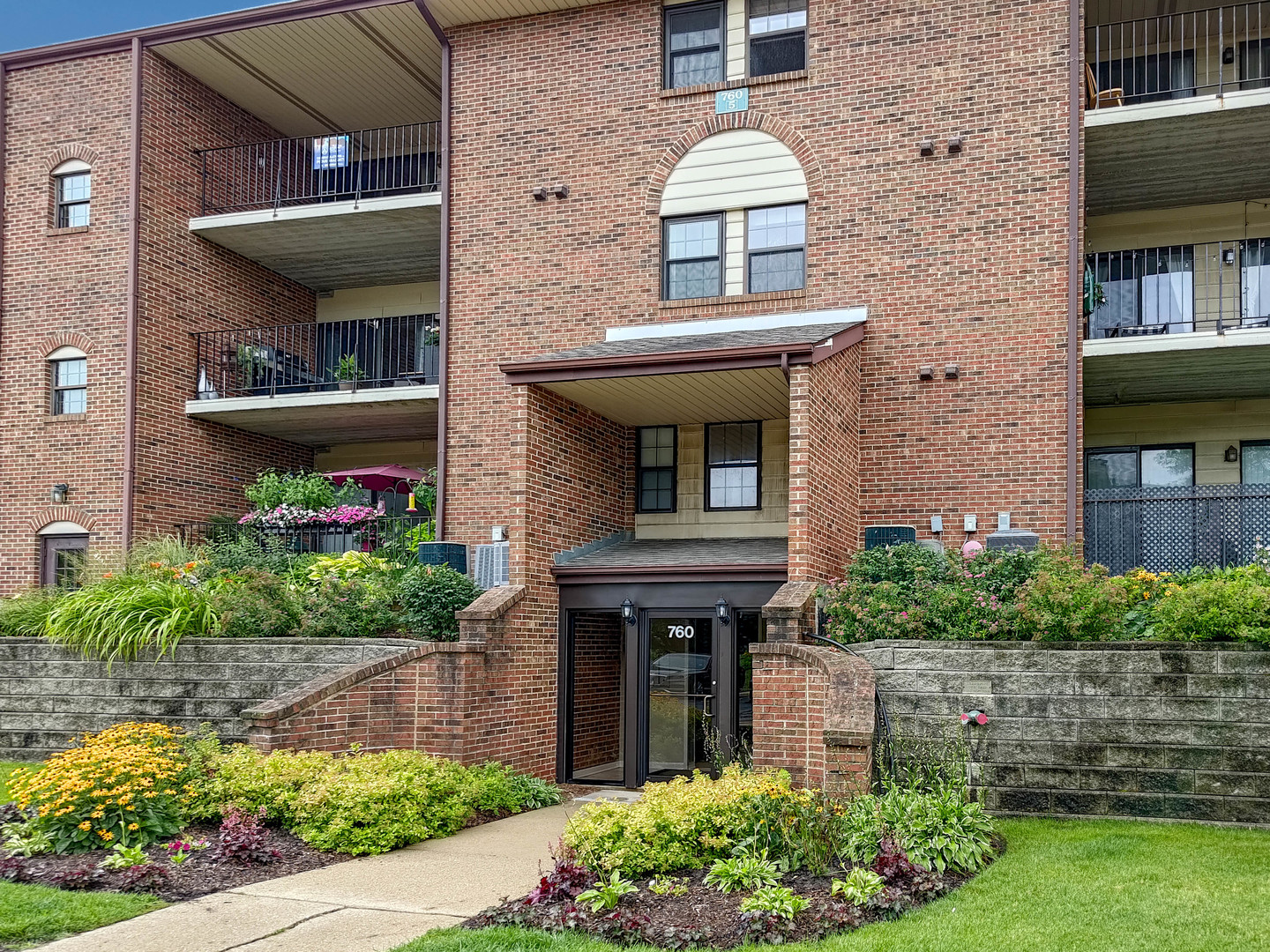 760 Weidner Road, Unit 106 Buffalo Grove, IL 60089 - Photo 3 of 20 a front view of a house with garden