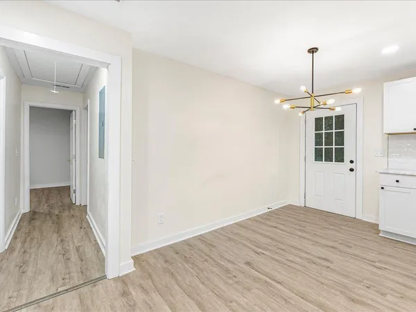a view of a room with wooden floor ceiling fan and windows